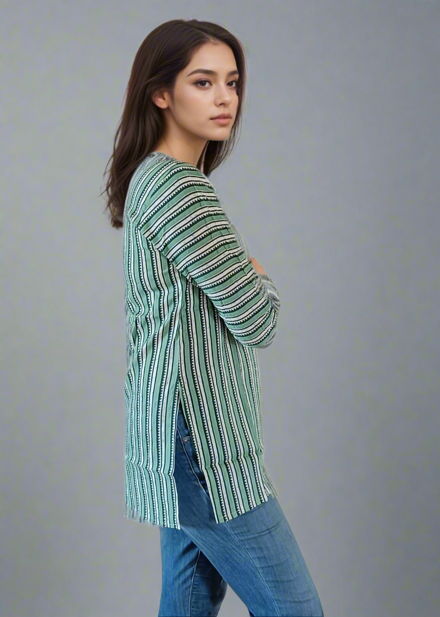 Woman wearing a green striped shirt and blue jeans on a plain background