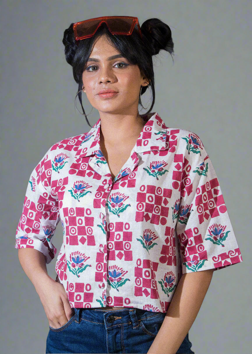 Person wearing a patterned shirt with a plain background