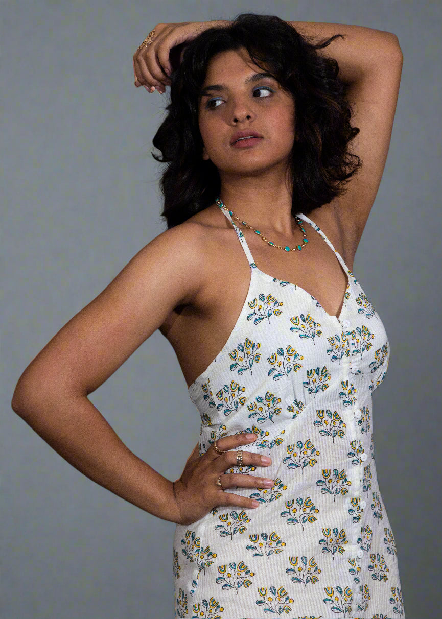 Woman wearing a white floral dress against a dark background