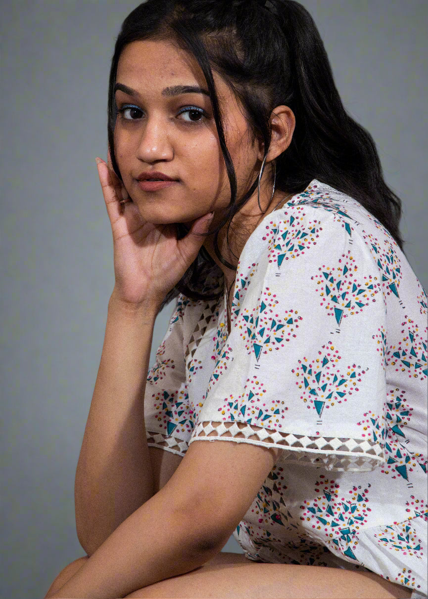 Woman wearing a floral blouse against a dark background