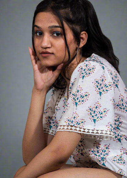 Woman wearing a floral blouse against a dark background