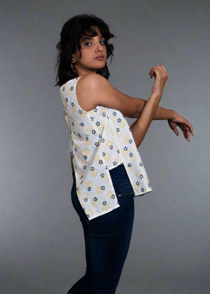 Person wearing a white sleeveless top with blue jeans on a dark background