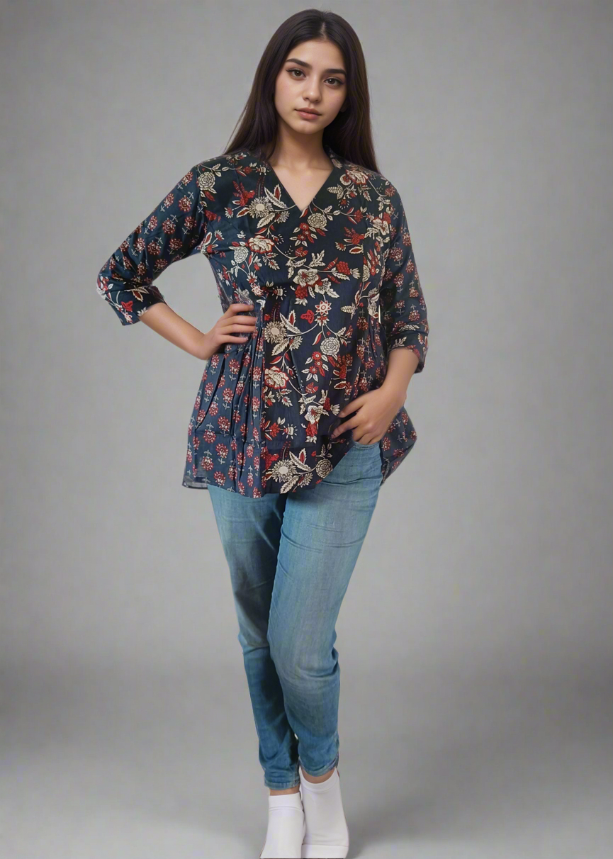 Woman wearing a floral flare tunic top blouse and blue jeans on a white background