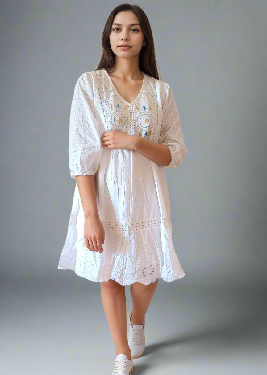 Woman wearing a white lace dress against a plain background