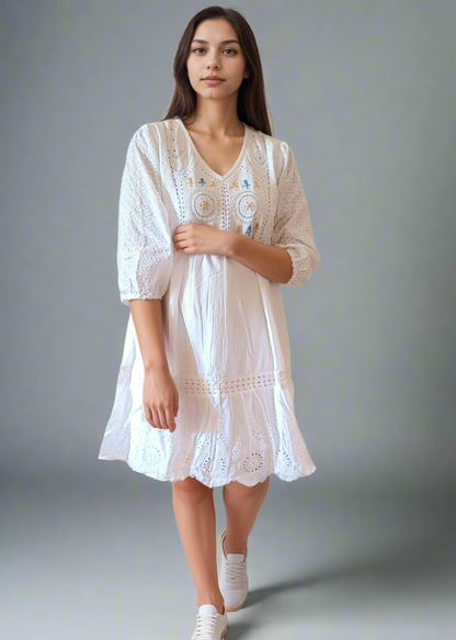 Woman wearing a white lace dress against a plain background