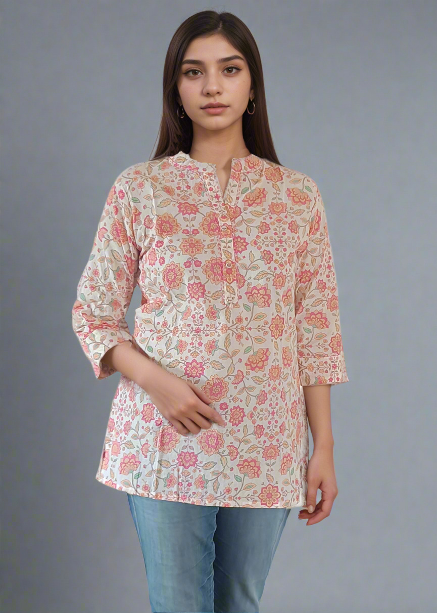 Woman wearing a floral blouse and blue jeans against a plain background