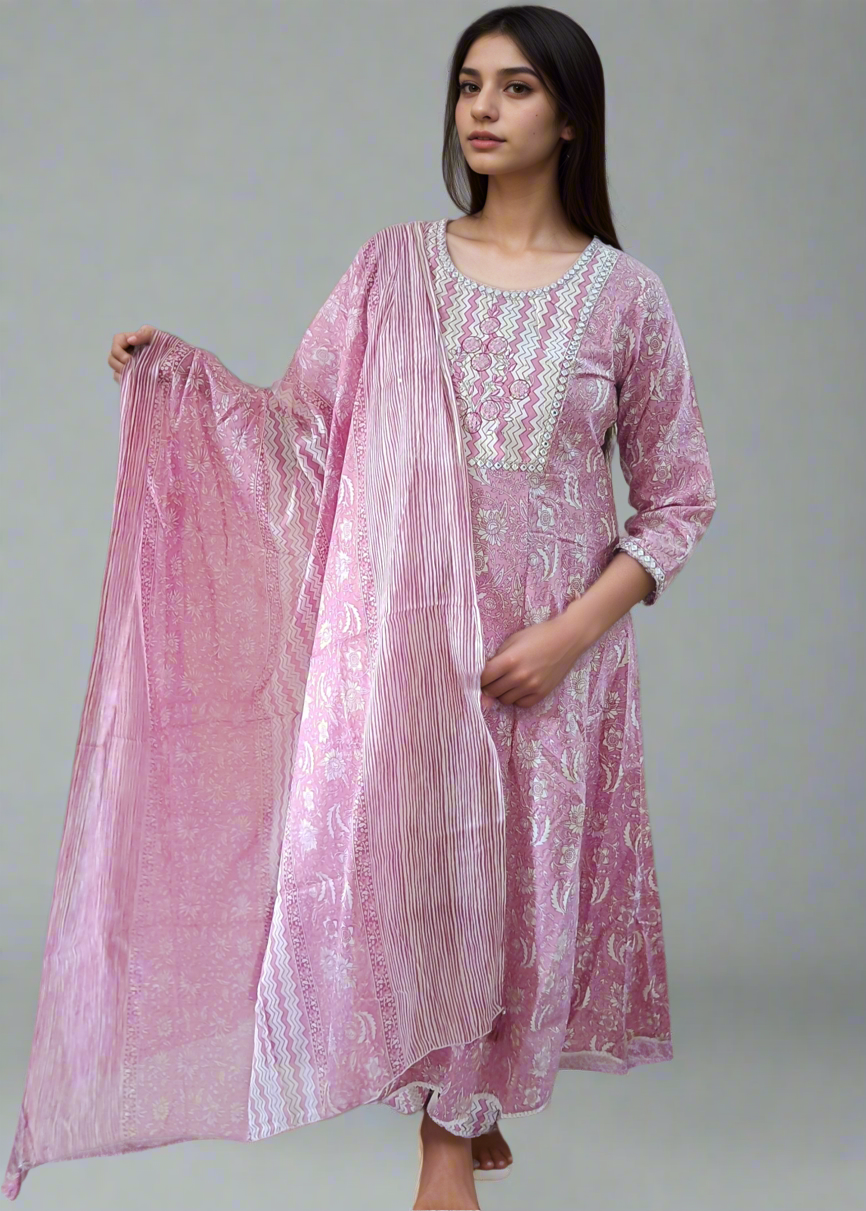 Woman wearing a pink traditional outfit with a matching dupatta on a neutral background