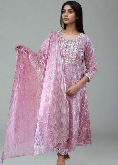 Woman wearing a pink traditional outfit with a matching dupatta on a neutral background