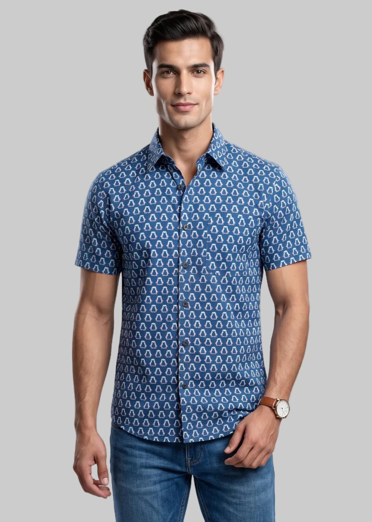 Man wearing a jaipuri cotton blue penguine patterned shirt and jeans on a gray background