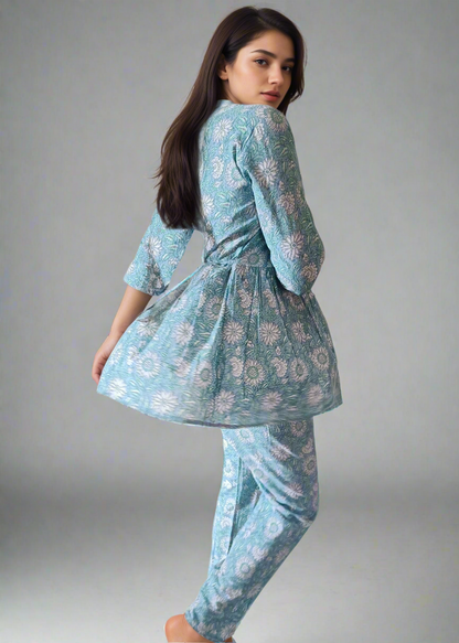 Woman wearing a light blue floral outfit against a plain background