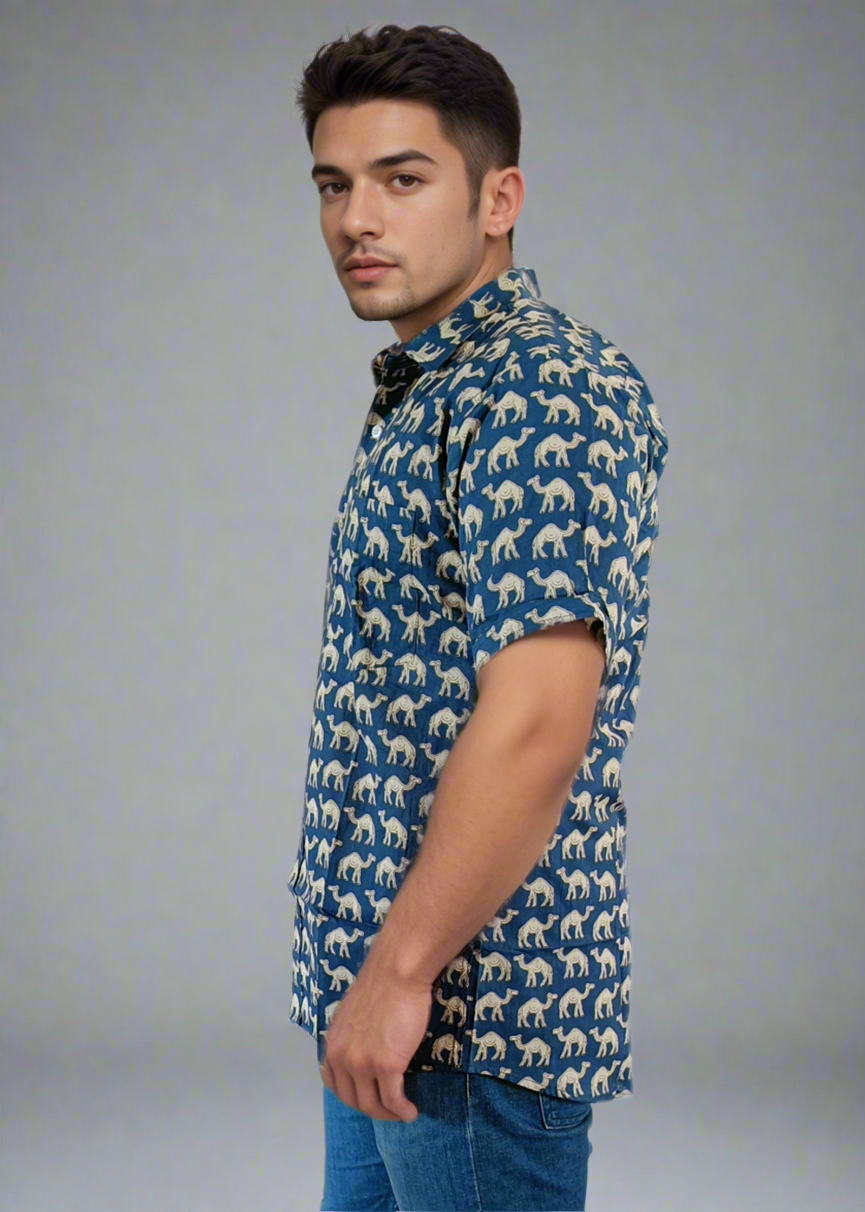 Man wearing a blue patterned shirt and jeans on a white background