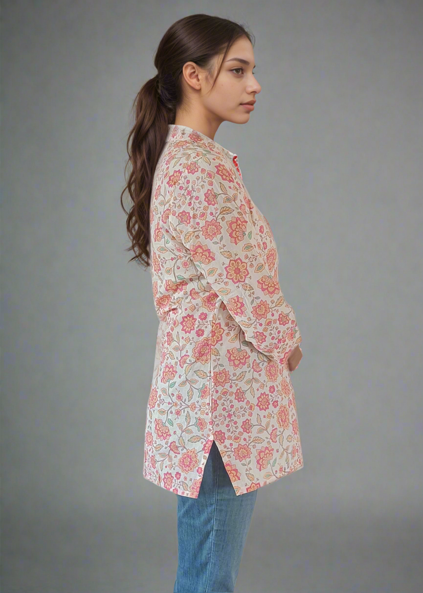 Woman wearing a floral blouse and blue jeans against a plain background