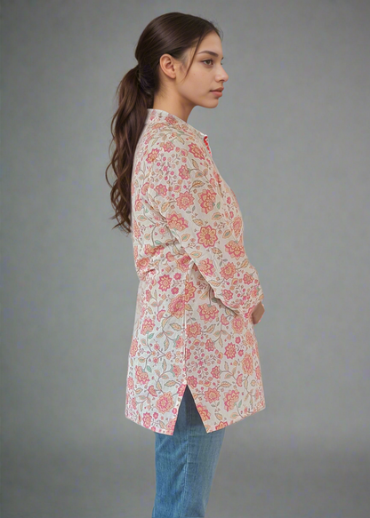 Woman wearing a floral blouse and blue jeans against a plain background