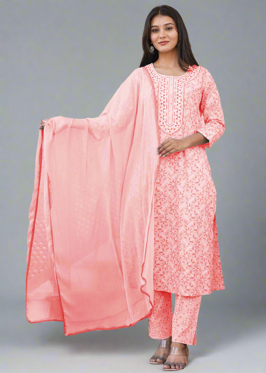 Woman in a pink traditional outfit standing on a staircase.