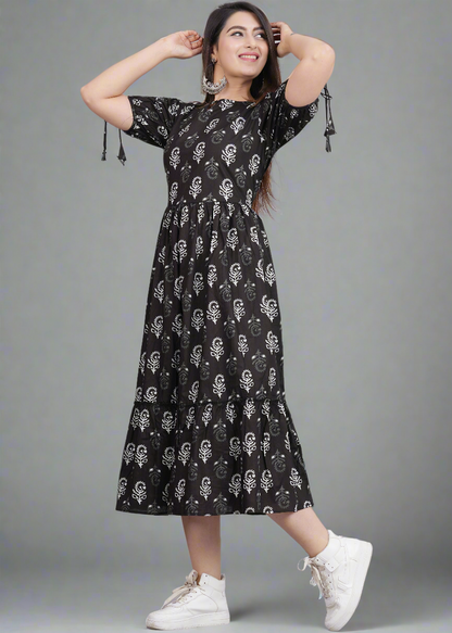 Woman wearing a black dress with white patterns on a gray background