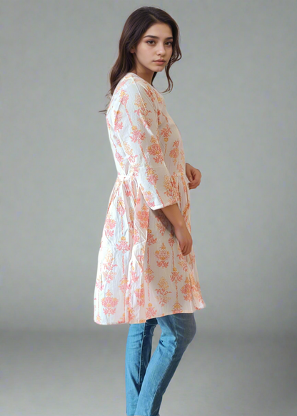 Woman wearing a floral dress and blue jeans on a plain background