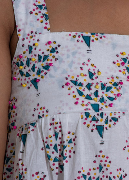 White dress with colorful geometric pattern on a plain background