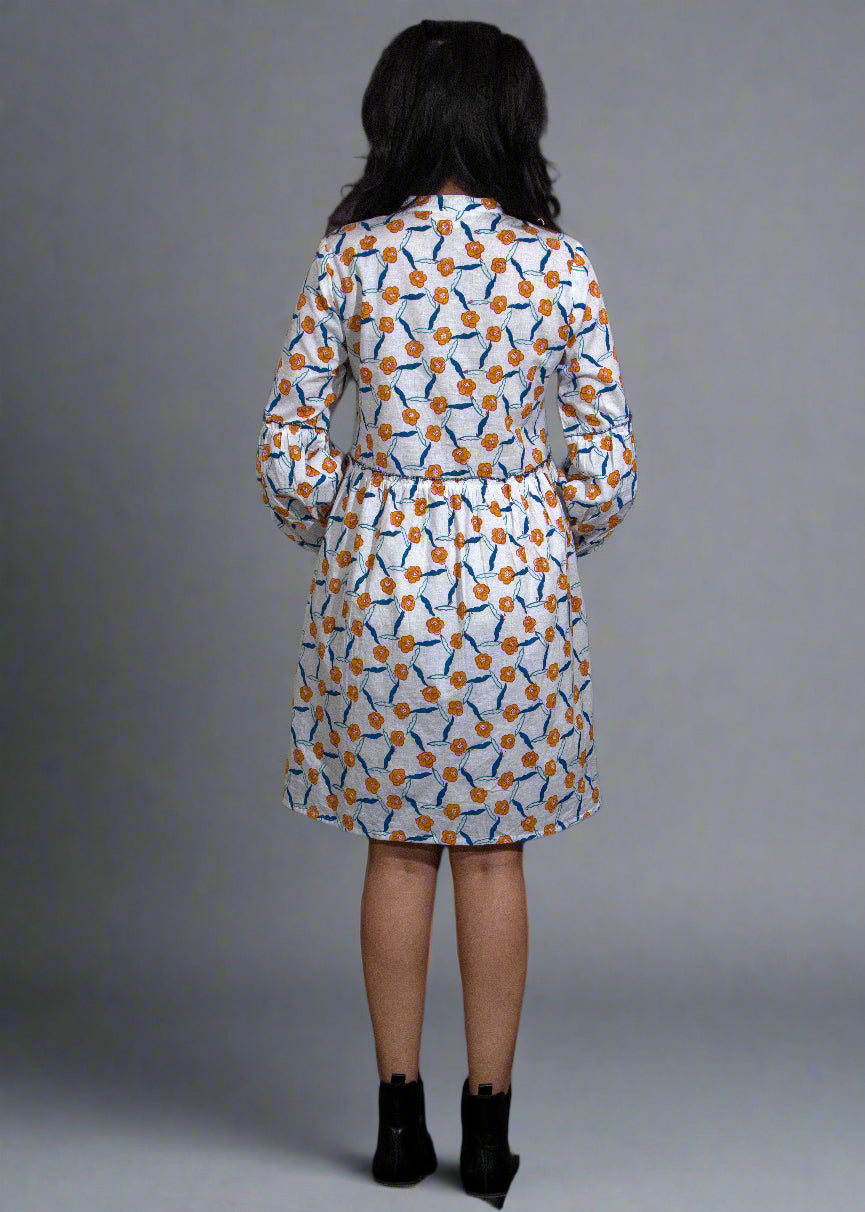 Woman wearing a hand block patterned dress against a black background