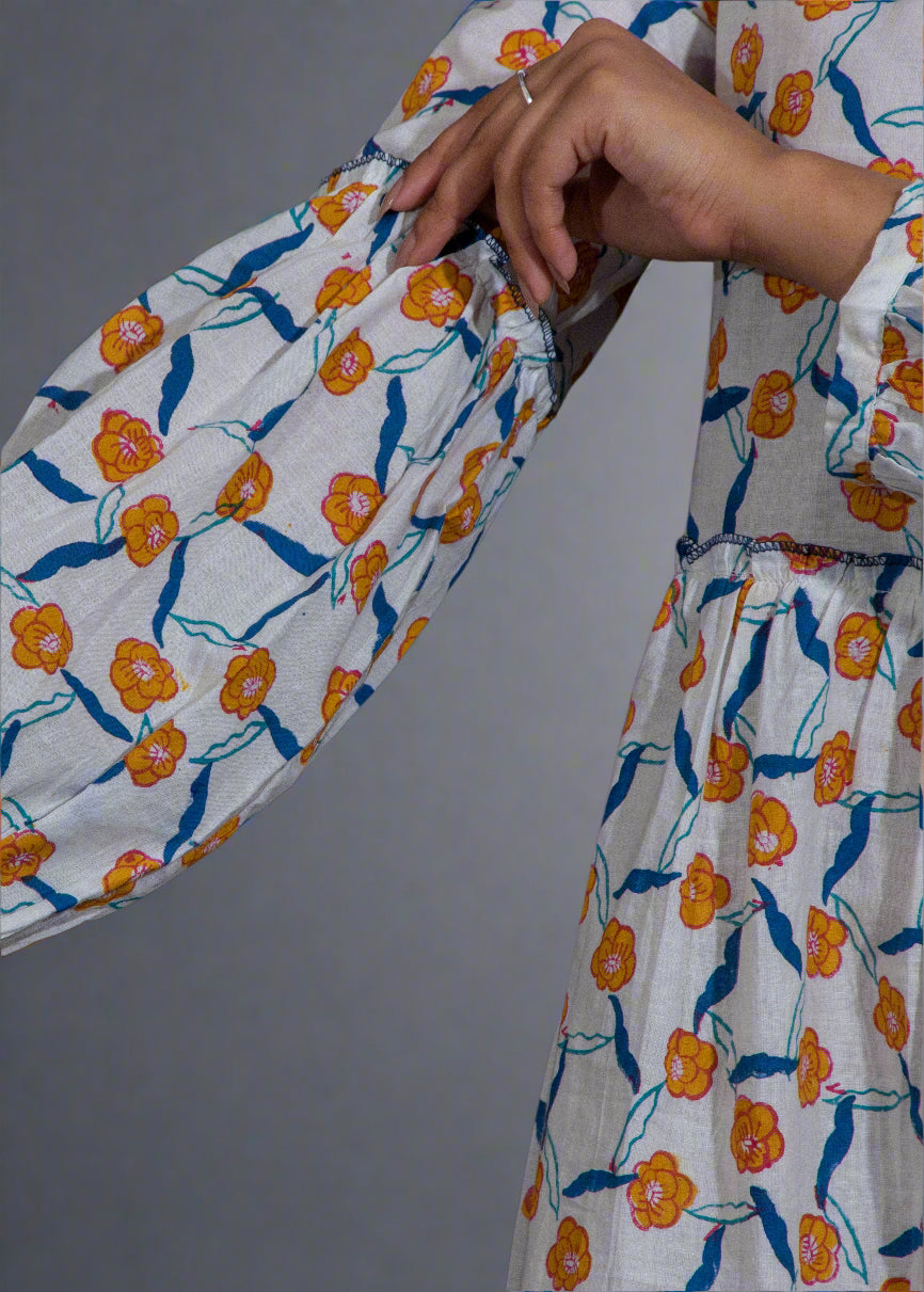Floral patterned puffed sleeve dress with orange and blue flowers on a plain background